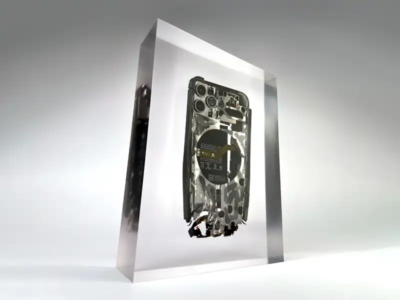 Ein stark beschädigtes Smartphone eingeschlossen in einem Kunstharz-Block